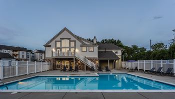A large house with a pool in front.